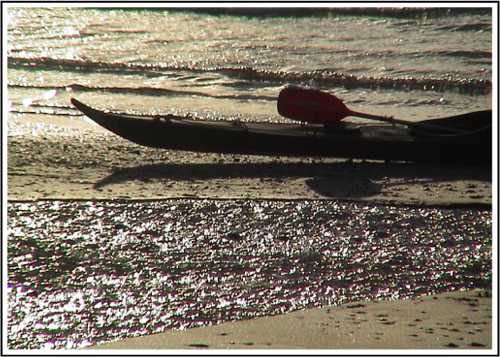 Stern of kayak on sunset beach