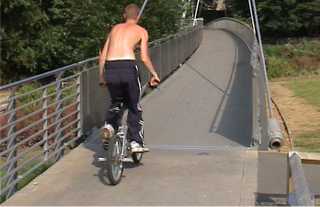 Boy cycling over footbridge