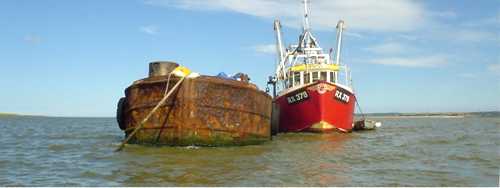 Anchored barge and fishing vessel